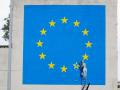 un trabajador martillando una de las 12 estrellas de la bandera de la Unión Europea que el artista pintó 2017