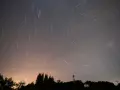 Fotografía de larga exposición durante la lluvia de estrellas de las Perseidas sobre la localidad cántabra de Comillas