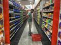 Un hombre revisa su móvil mientras compra comida en un supermercado, hoy, en Caracas (Venezuela)