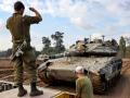 Un tanque de combate israelí es replegado de la frontera con Gaza