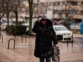 Una persona se protege de la lluvia en Madrid