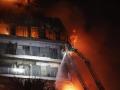 Un bombero subido a una escala lucha contra las llamas en el edificio devorado por las llamas en Valencia