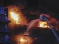 Un bombero subido a una escala lucha contra las llamas en el edificio devorado por las llamas en Valencia