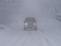 Un vehículo circula por una carretera cubierta de nieve este lunes en O Cebreiro, Lugo