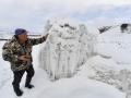 El granjero Erkinbek Kaldanov, de 54 años, inspecciona el glaciar artificial en un desfiladero de montaña cerca del pueblo de Syn-Tash