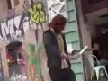 Un hombre se pasea por el barrio de El Raval mientras afila un cuchillo