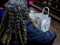 Una mujer con una de las bolsas de comida preparadas por la ONG Mensajeros de la Paz