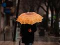 Una persona se protege de la lluvia con paraguas