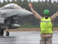 Un militar realiza señales a un avión.