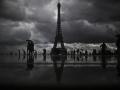 Transeúntes pasean bajo la lluvia frente a la Torre Eiffel