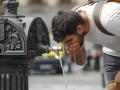 Un hombre bebe agua en una fuente pública del centro de Madrid
