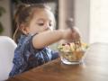 Niña pequeña comiendo una macedonia de fruta