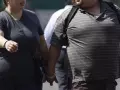 Dos personas con sobrepeso caminan por la calle