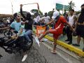 Un manifestante patea una pancarta de campaña del presidente venezolano Nicolás Maduro durante una protesta en Valencia, estado Carabobo, Venezuela