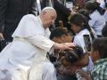 Pope Francis (L) blesses a man and his child during his visit to the Irmas Alma School for Children with Disabilities in Dili on September 10, 2024. (Photo by Tiziana FABI / AFP)