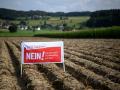 En esta fotografía, un agricultor coloca una pancarta electoral en la que se lee "¡No a las iniciativas extremas de biodiversidad!"