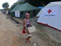 Una mujer carga con una caja de donaciones a la Cruz Roja