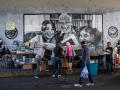 Un grupo de personas caminando frente a vendedores informales de libros en Caracas (Venezuela)