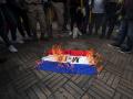 Manifestantes queman una bandera de la guerrilla M-19 durante una protesta contra el gobierno del presidente colombiano Gustavo Petro