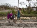 Una mujer arrastra un coche de bebé por una de las calles de playa Guanimar