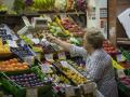 Una mujer compra en uno de los puestos del mercado de abastos de Triana (archivo)