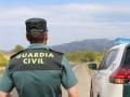 Un agente de la Guardia Civil junto a un vehículo en una carretera