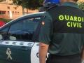 Imagen de archivo de un agente de la Guardia Civil ante un coche patrulla