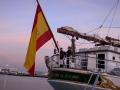 Arriado de la bandera de España al atardecer en Elcano