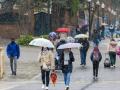 Varias personas caminan bajo la lluvia este lunes en Teruel cuando la Agencia Estatal de Meteorología (Aemet)