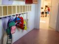 Varias mochilas en una percha de un aula infantil