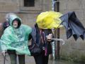 Turistas en la plaza del Obradoiro en Santiago de Compostela con el temporal