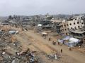 La gente camina entre los edificios derrumbados a lo largo de la calle Saftawi en Yabalia, en el norte de la franja de Gaza