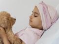 Niña con cáncer con un perrito de peluche