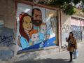 Una mujer pasa junto a un mural que representa a la familia Bibas, retenida por Hamás en Gaza desde el 7 de octubre de 2023, en un muro de la ciudad costera israelí de Tel Aviv