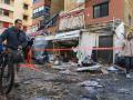 Residentes locales caminan entre escombros frente a un edificio de apartamentos tras un ataque israelí en Sidón