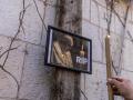 Un hombre enciende una vela junto a una foto del Papa Francisco en la Ciudad Vieja de Jerusalén