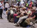 Multitud de personas, en su mayoría viajeros, se preparan para pasar la noche en la estación de trenes de Sevilla-Santa Justa, afectados por el apagón general