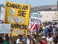 Los colectivos sociales, ecologistas y ciudadanos que impulsaron hace un año las protestas contra los impactos del turismo de masas vigente en Canarias han vuelto a salir este domingo a las calles de las islas, para exigir, por millares, una operativa más sostenible del motor económico del archipiélago. En la imagen, manifestación en Puerto del Rosario, en Fuerteventura.