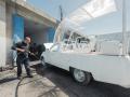 Un operario de Cáritas Jerusalén limpia a fondo el papamóvil-ambulancia