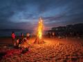 Los asistentes contemplan hipnotizados las llamas de las hogueras encendidas en la playa coruñesa de Riazor durante la celebración de la noche de San Juan