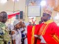 Monseñor Ernest Obodo crisma la frente de una joven nigeriana