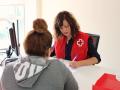 Voluntaria de Cruz Roja atendiendo a una demandante
