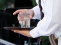 Imagen de un camarero sirviendo un vaso de agua a un cliente
