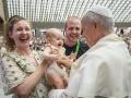Pope Leo XIV blesses a family during the general audience in Paul VI Hall at the Vatican on August 27, 2025. (Photo by Filippo MONTEFORTE / AFP)