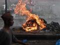 Un hombre camina junto a una pira en las calles de Nepal