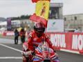 Marc Márquez celebra la victoria con una bandera de España