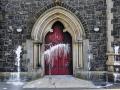 The door of a Roman Catholic Church suffers scorch damage from petrol bombs and paint during a sectarian attack