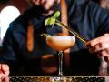 Close-up of a bartender garnishing a fresh cocktail in the pub