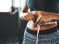 Cropped shot of a fit young woman measuring her waist in a gym