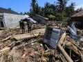 Residentes caminan entre grandes pilas de madera arrastradas por las inundaciones en una aldea afectada por las inundaciones en la zona de Meureudu, Pidie Jaya, Aceh, Indonesia